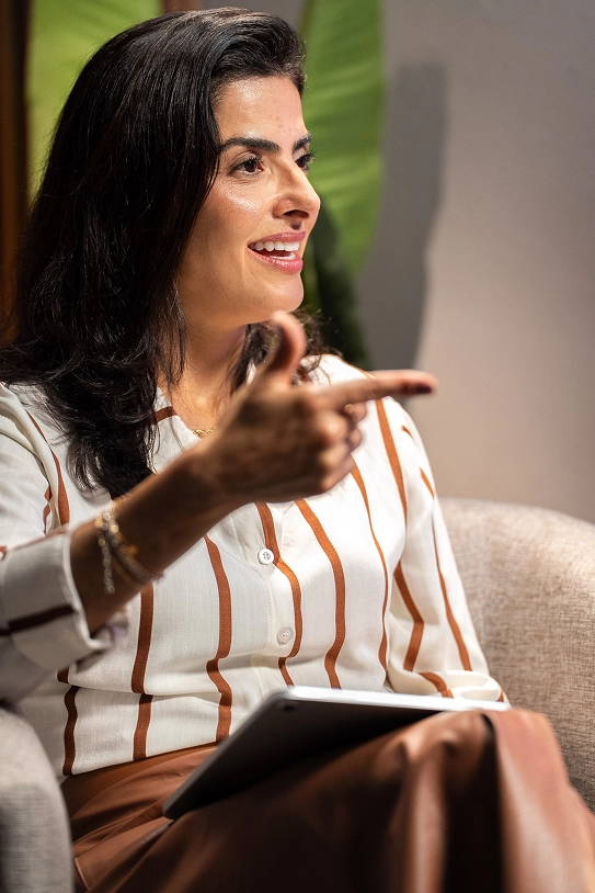 Dra. Lidiana durante gravação do podcast, apontando enquanto conversa